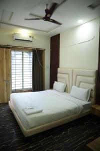 a bedroom with a large white bed with a ceiling at Shiv Resort & Palace in Shivpurī +31 photos
