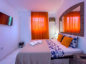 a bedroom with an orange window and a bed with towels at SSA 33 Hotel in Salvador +101 photos