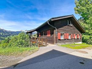 a wooden house with red doors on a hill at Chalet Egg-Isch by Interhome in Grindelwald