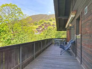 a wooden deck with two chairs and a table on it at Chalet Egg-Isch by Interhome in Grindelwald +30 photos