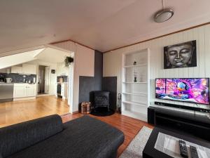 a living room with a couch and a flat screen tv at Rooftop view apartment 2 in Vardø
