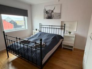 a bedroom with a bed with a bull picture on the wall at Rooftop view apartment 2 in Vardø