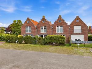 a brick house with a fence in front of it at Villa Petra in Norddeich