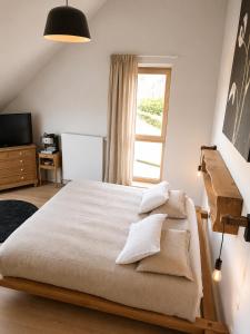 a bedroom with a large bed and a window at Hors-Champs in Gembloux