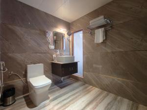 a bathroom with a toilet and a sink and a mirror at Valmere Bayul Shangri-La Resort in Lachung +40 photos