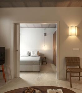 a bedroom with a bed and a living room at Apartamentos Turísticos A Mariña Do Carril in Vilagarcia de Arousa