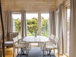 a dining room with a table and chairs and windows at Holiday Home Ringenäs by Interhome in Halmstad +20 photos