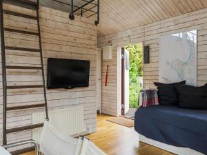 a room with a bed and a tv on a wall at Holiday Home Ringenäs by Interhome in Halmstad