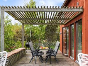 a pergola on a deck with a table and chairs at Holiday Home Ringenäs by Interhome in Halmstad
