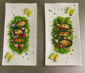 two plates of food with mussels and lettuce at Gadea Boutique Hotel in Jambiani