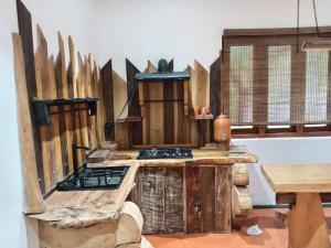 a kitchen with a stove and a bunch of knives at The Wood Cottage in Elkaduwa
