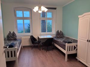a room with two beds and a table and chairs at Bahnhof Mulknitz in Forst