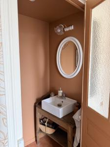 a bathroom with a white sink and a mirror at Maison Bécharie in Uzerche +11 photos