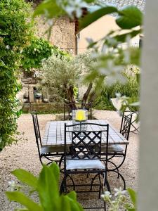 a table and chairs in a garden at La Suite Drômoise 1809 in Saint-Paul-lès-Romans