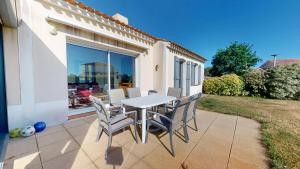 a patio with a table and chairs on the side of a house at Villa BlueGreen in Coëx
