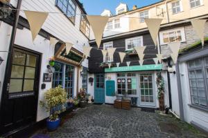 a row of buildings with flags hanging from them at 1 Bed in St. Ives oc-drift4 in St Ives