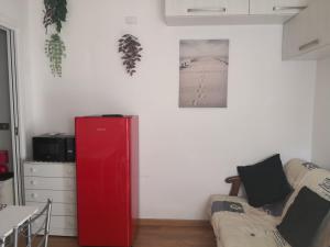 a living room with a red cabinet and a couch at Il mare ad un passo in Varazze
