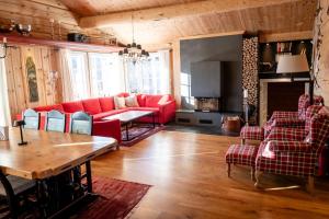 a living room with a red couch and a table at Budalen, spacious cabin close to skitracks in Holo