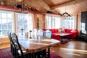 a living room with a table and a red couch at Budalen, spacious cabin close to skitracks in Holo