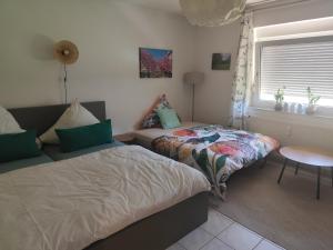 a bedroom with two beds and a table and a window at Little Castle in Bad Kreuznach