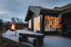 a fire pit in front of a house at Budalen, spacious cabin close to skitracks in Holo