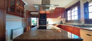 a kitchen with wooden cabinets and a granite counter top at Villa Merce in Botarell