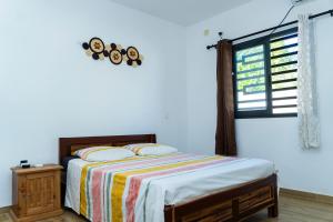a bedroom with a bed and a window at Résidence Vahi-Ni, Villa Faniry in Hell-Ville +16 photos