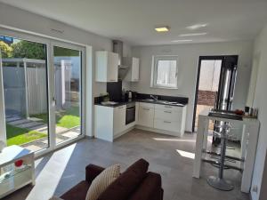 a kitchen with white cabinets and a couch in a room at Studio in Wincheringen in Wincheringen