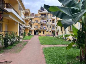 a path in front of a building with a banana tree at Baga Central Studio Apartment in Baga