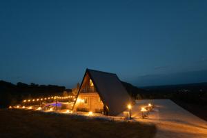 a large wooden building with lights on it at night at BEV's Hideaway in Gornji Kosići +76 photos