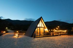 a large building with a triangular roof at night at BEV's Hideaway in Gornji Kosići