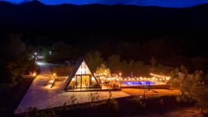 a glass house is lit up at night at BEV's Hideaway in Gornji Kosići