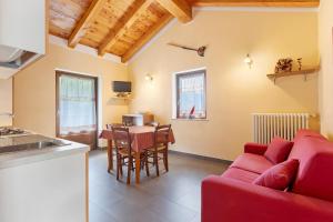 a living room with a red couch and a table at La Baita - Bionaz in Bionaz