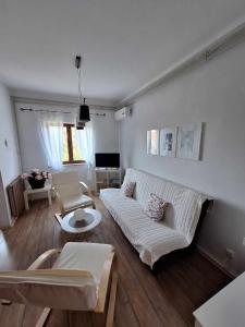 a living room with a white couch and a table at Apartmani Tara Medulin in Medulin