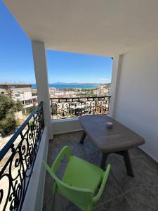 a balcony with a table and a green chair at Résidence Les Camélias in Tabarka