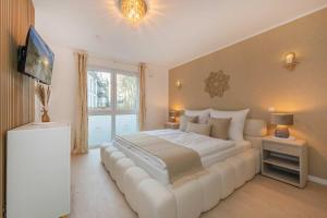 a bedroom with a large white bed with a white couch at Ferienwohnung Goldkind in Kölpinsee