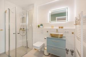 a bathroom with a toilet and a sink and a shower at Ferienwohnung Goldkind in Kölpinsee +29 photos