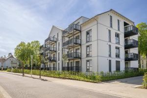 an apartment building with balconies on a street at Ferienwohnung Goldkind in Kölpinsee