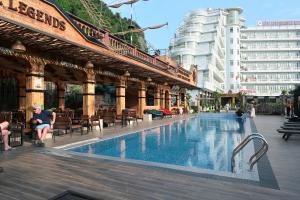 a swimming pool in a building with tables and chairs at Hung Long Harbour Hotel in Cat Ba