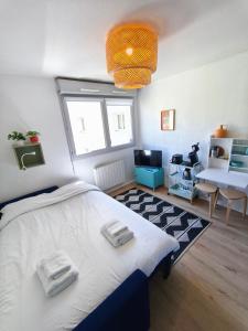 a bedroom with a large bed with two towels on it at Studio calme Cite Internationale Wifi in Caluire-et-Cuire