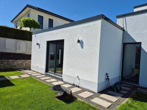 a white house with glass doors in a yard at Studio in Wincheringen in Wincheringen