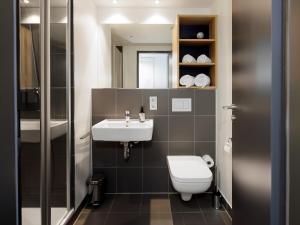 a bathroom with a white toilet and a sink at smartments Berlin Karlshorst in Berlin +30 photos