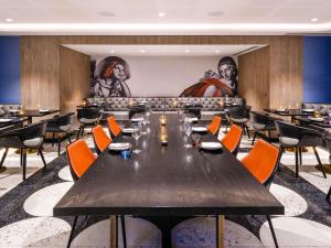 a dining room with a large table and chairs at Mövenpick Hotel Hobart in Hobart