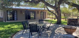 a patio with a table and chairs under a tree at Zebra game farm in Brits