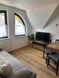 a living room with a bed and a table and a tv at Apartmaji Anže Kranjska Gora in Kranjska Gora