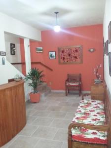 um quarto com uma cama e uma parede vermelha em Pousada Caminho da Serra em Tiradentes