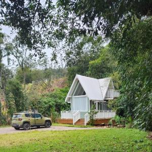 a house with a car parked in front of it at Chalé Villa Mount in Timbe do Sul