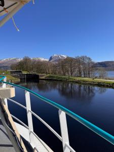 a bridge over a river with mountains in the background at Nova Spero Boat & Breakfast - Caledonian Canal in Fort William