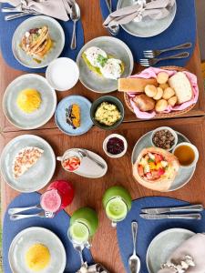 a wooden table with plates of food on it at Pousada Aysú in Japaratinga