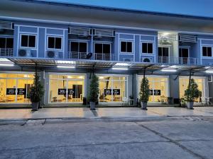 a building with potted trees in front of it at The Chill Town Home in Maha Sarakham